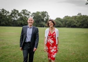 Man_and_woman_in_business_attire_walking_towards_camera_in_a_field